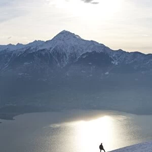 Silhoutte of a hiker facing Mount Legnone and Lake Como at sunset, Lombardy, Italy, Europe