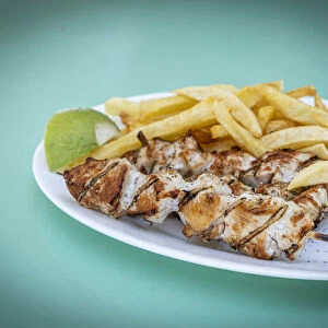 Souvlaki, popular Greek food consisting of small pieces of meat grilled on a skewer served with french fries, Greek Islands, Greece, Europe