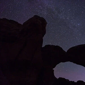 Starry sky viewed through Broken Arch, Arches National Park, Utah