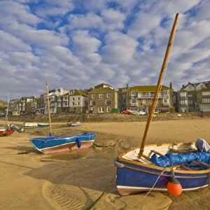 Strange cloud formation in the early morning with small Cornish fishing boats at low tide in the harbour at St. Ives, Cornwall, England, United