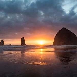 Sunset behind Haystack Rock at Cannon Beach on the Pacific Northwest coast, Oregon