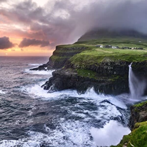 Sunset at the waterfall and cliffs of Gasadalur, Faroe Islands, Denmark, Europe