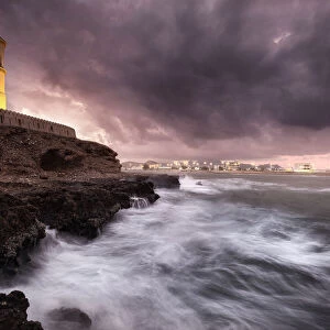 Sur lighthouse with the stormy sea on the cliff and a pink sunset, Sur, Oman, Middle East