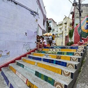 Tourists sitting on Selaron Steps, 215 decorated steps the work of artist Jorge Selaron