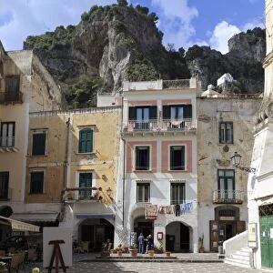 Town square with restaurant tables and colourful buildings, star shaped paving, Atrani
