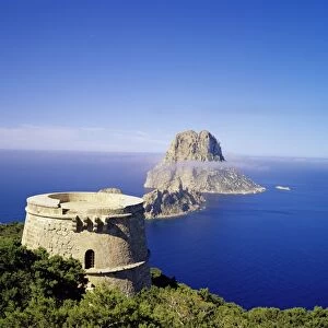 View of defence tower and the rocky island of Es Vedra