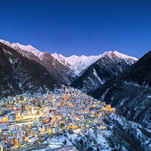 View by drone of winter dusk over the illuminated village of Premana, Valsassina
