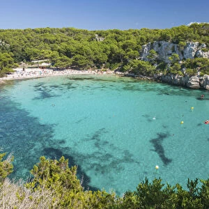 View over the turquoise waters of Cala Macarella to pine-fringed sandy beach