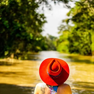 Woman searching for wildlife on the Amazon River, Peru, South America