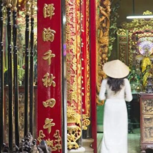 Woman wearing ao dai dress at Phuoc An Hoi Quan Pagoda, Cholon, Ho Chi Minh City