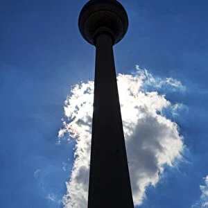 Silhouette of the Berlin TV Tower, Fernsehturm, television tower and a cloud in Berlin, Germany