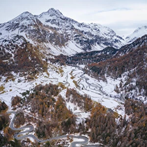 Aerial view of curves of Maloja Pass road and Piz da la Margna in autumn, Bregaglia Valley, Graubunden, Engadine, Switzerland