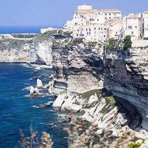 Blue sea frames the medieval old town and fortress perched on top of cliffs Bonifacio