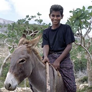 A boy rides home after school on a donkey in the Homhil Mountains