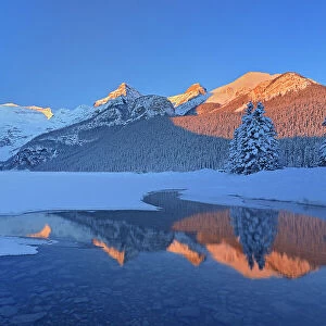 The Canadian Rocky Mountains reflected in Lake Louise at sunrise. Victoria Glacier on Mt. Victoria at left. Then from left to right is Mt. Whyte, The Big Beehive and Mt. Niblock and Mt. St. Piran. Banff National Park, Alberta, Canada
