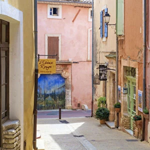 Colorful ochre colored buildings on a street in Roussillon, Vaucluse, Provence-Alpes-CA'te