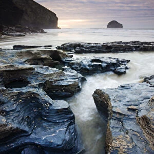 Eroded slate rocks on the beach at Trebarwith Strand, looking towards Gull Rock