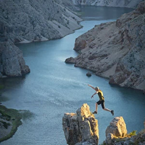 Europe, Balkan, Croatia, man with hat jumping at Zrmanja canyon