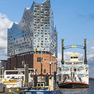 Germany, Hamburg, HafenCity. Boats docked near the Elbphilharmonie (Elbe Philharmonic