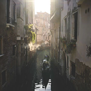 A gondola cruising a little canal during the morning in Venice, Veneto, Italy