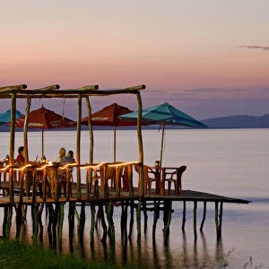 Guatemala, El Peten, Flores, Lago de Peten Itza, People eating at lakeside restaurant