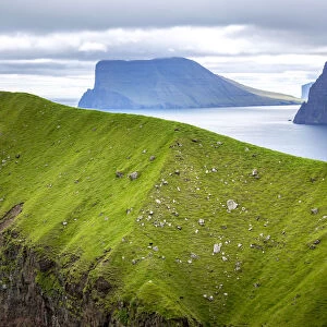 Hiker over a cliff in Kalsoy, Faroe Islands, Europe