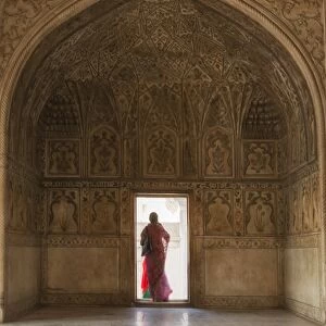 India, Uttar Pradesh, Agra, Agra Fort, a woman in a red saree walks through the interior