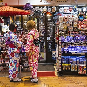 Japan, Honshu, Tokyo, Asakusa, Two Woman Dressed in Kimono in front of Souvenir Shop
