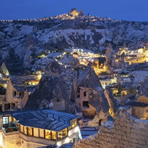 Landscape of the ancient town of Goreme at duskwith Uchisar fortrees in the background