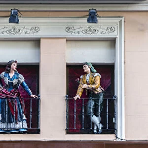 Man and woman sculptures with traditional Spanish dressed on the balconies, Paseo