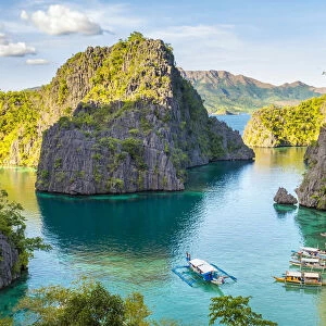 Outrigger boats and small village in a rocky inlet on Coron Island, Coron, Palawan