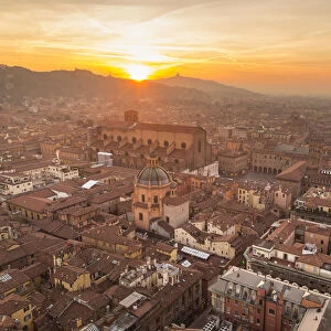 Panorama from Asinelli tower at sunset to Old city of Bologna with San Luca church in the