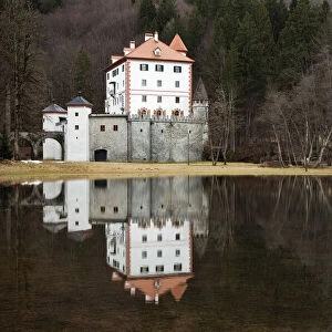 Sneznik Castle reflected in winter floodwater, near Kozarisce, Notranjska, Slovenia