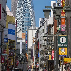 Street in Shinjuku district with Cocoon Tower in the background, Tokyo, Japan