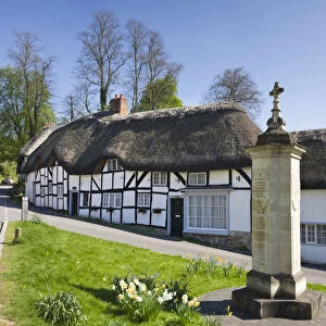 Thatched cottages and war memorial in the village of Wherwell, Hampshire, England