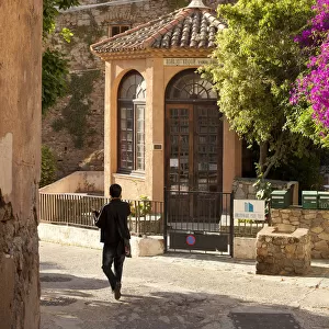 A tourist walks down the street in Calvi on the island of Corsica