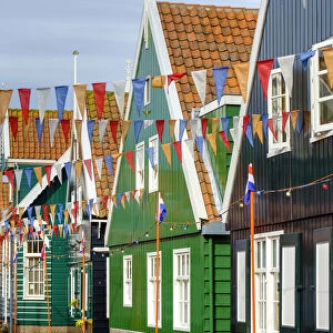 Traditional wooden houses decorated with flags of Dutch national colors for Koningsdag