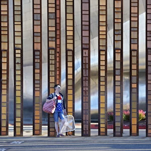 USA, Washington, Seattle, EMP Museum, Man standing on street with handbag and fan