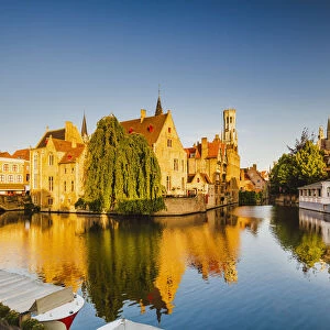 View of Bruges old town reflecting in the water canal at sunrise, Belgium