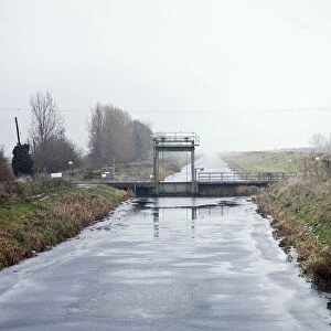 Welney, Cambridgeshire, UK. A frozen drainage ditch attracts skaters