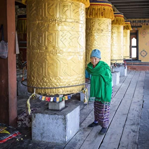 Woman spinning prayer wheels at the National Memorial Chhorten, Thimphu, Bhutan