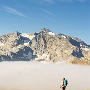 Young hiker walking along hill of Nivolet with Grand Aiguille Rousse in the background
