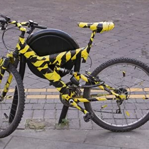 A bike wrapped in black and yellow tape