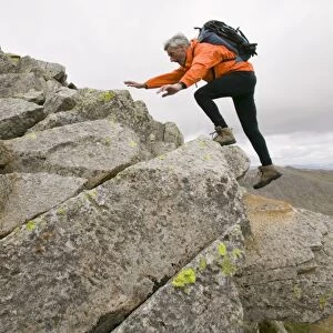 A climber scrambling in Eskdale in the Lake District UK
