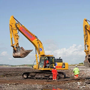 Construction workers working on the foreshore of the Solway Firth near Workington, installing the power cable that will carry the electricity from the new Robin Rigg offshore wind farm in the Solway Firth. Robin Rigg is one of the largest wind