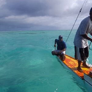 Marshalhese men steering a traditional outrigger canoe, Ailuk atoll, Marshall Islands, Pacific