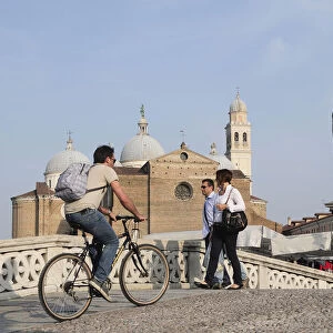 Italy, Veneto, Padua, cyclist crossing bridge on Isola Memmia e Zairo Teatro Romano