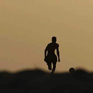 Angolan youths play soccer on the beach in the capital Luanda