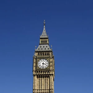 Big Ben Clock Tower above the Houses of Parliament is surrounded by blue sky in London