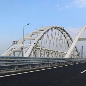 Cars drive along a bridge, which was constructed to connect the Russian mainland with the